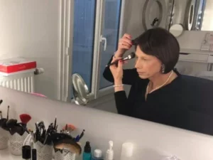 femme se maquillant devant un mirorir
