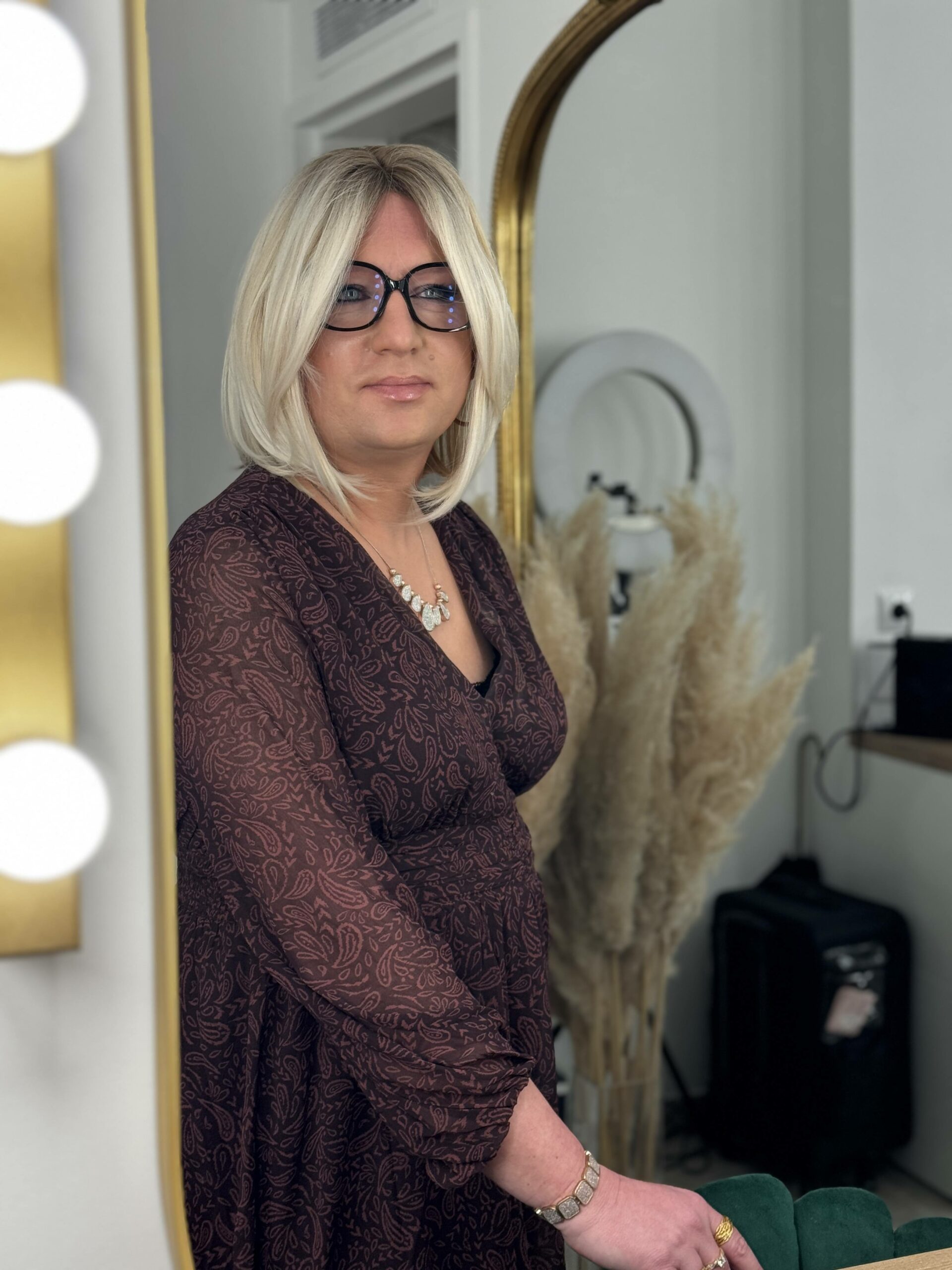 Stéphanie après une séance Transbeauté : maquillage et féminisation pour travesti, avec perruque blonde et robe bordeaux
