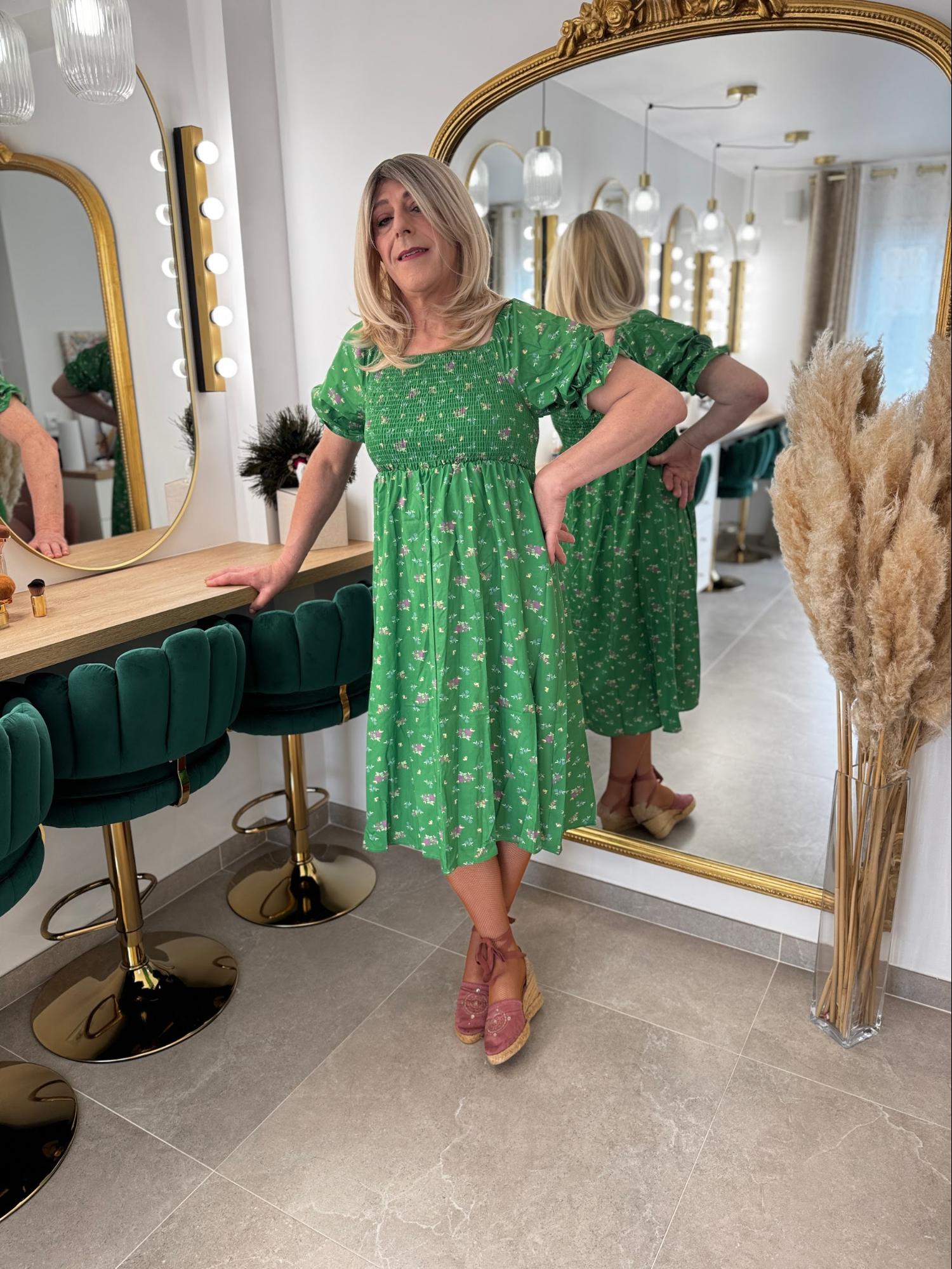Patricia, femme transgenre, pose en robe verte au studio Transbeauté après une séance de maquillage et de féminisation.