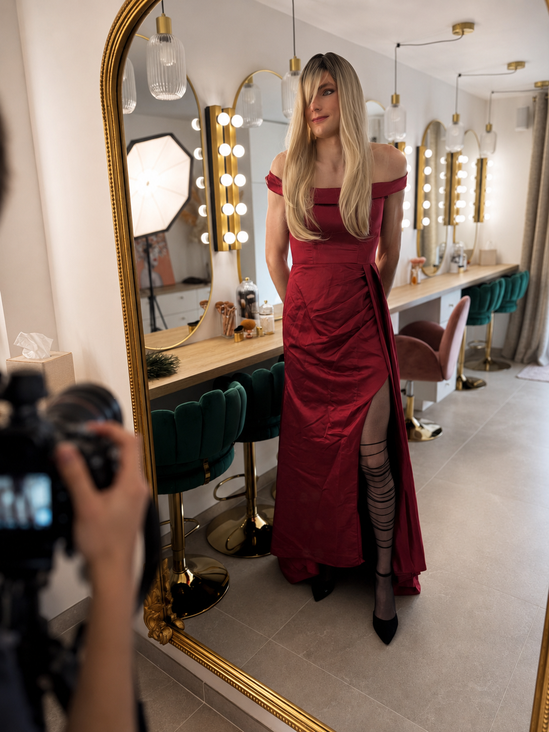 Personne travestie en robe rouge photographiée devant un grand miroir dans le studio Transbeauté.
